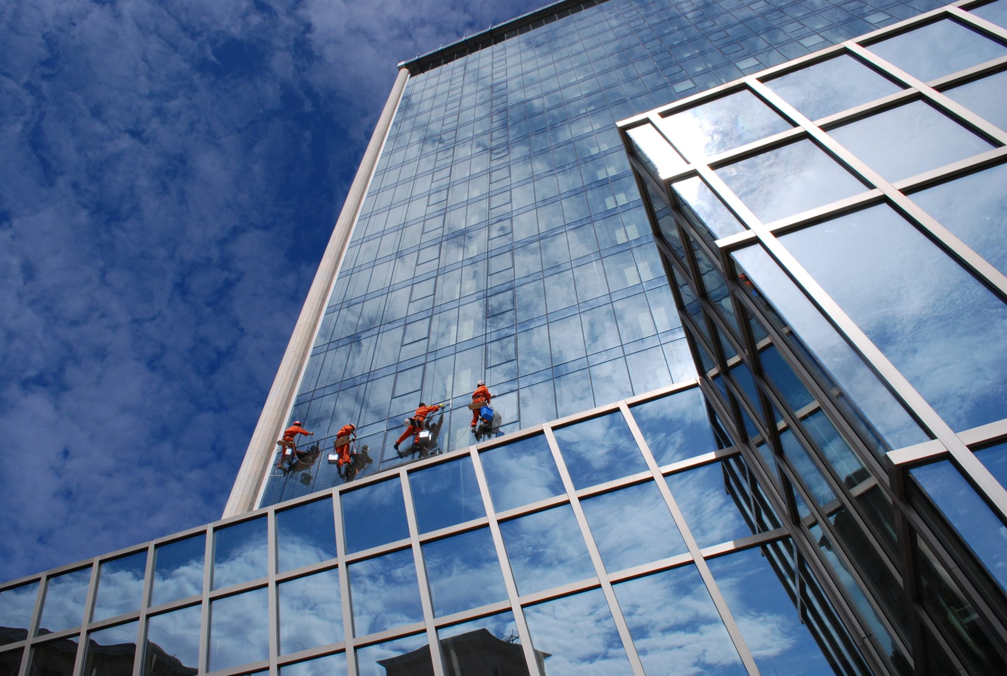 Oritoki rope-access technicians working on a glass high-rise