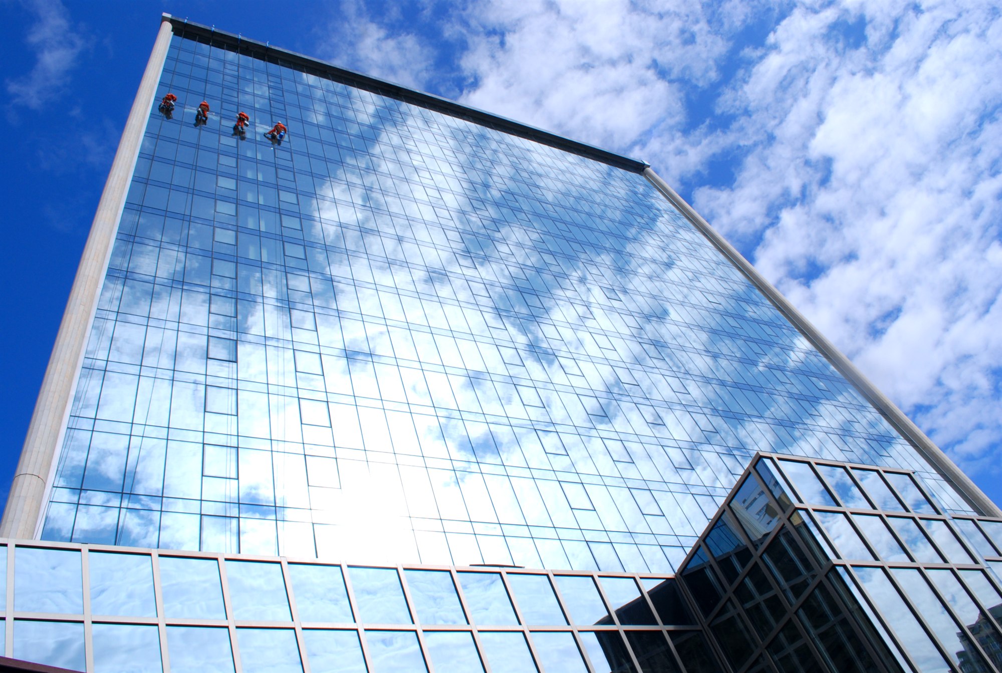 Oritoki rope-access technicians on a glass skyscraper facade